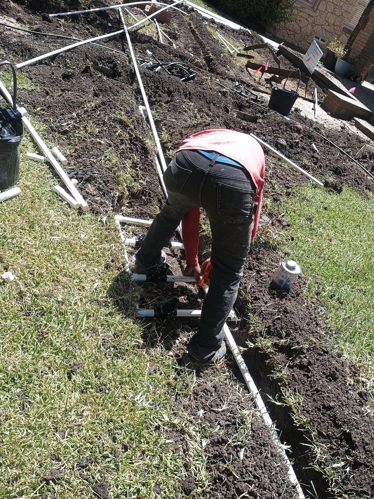 Technician installing an irrigation manifold with multiple zone valves