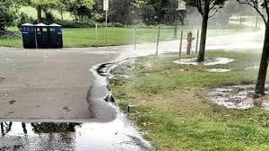 Wasted irrigation water running down a street from an undetected system leak